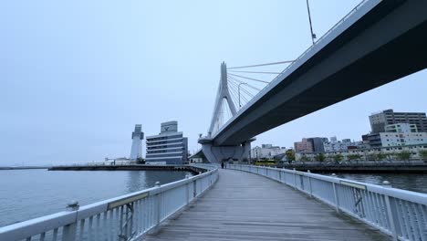modern bridge over aomori bay with a wooden pier walkway on a calm cloudy day
