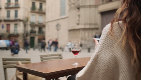 brunette woman using smartphone on a terrace