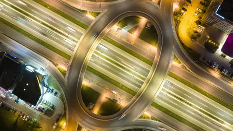 aerial night view of a busy highway interchange with light trails