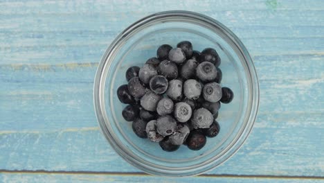 Timelapse-footage-of-freezing-fruits,-berries-on-the-glass-plate.-Frozen-food.-Frosting-of-blueberry