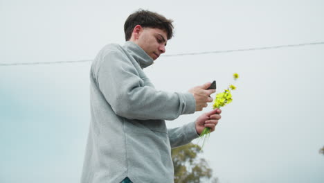 man doing a picture of the flowers he picked for valentines day