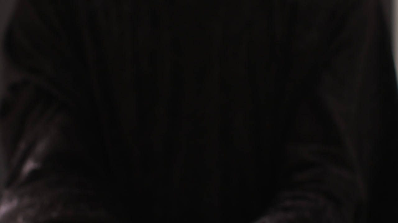 manos orando en fondo negro con espacio para copiar