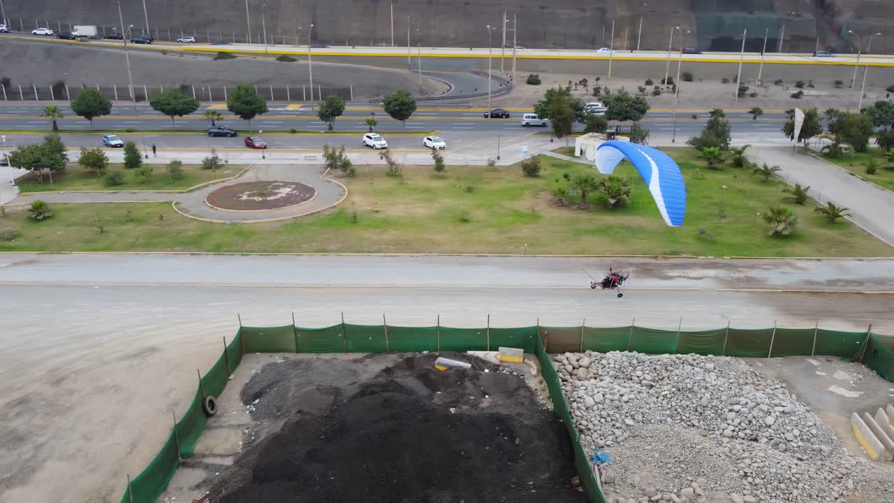 video de drones de un parapente aterrizando suavemente en una pista de tierra en lima, perú