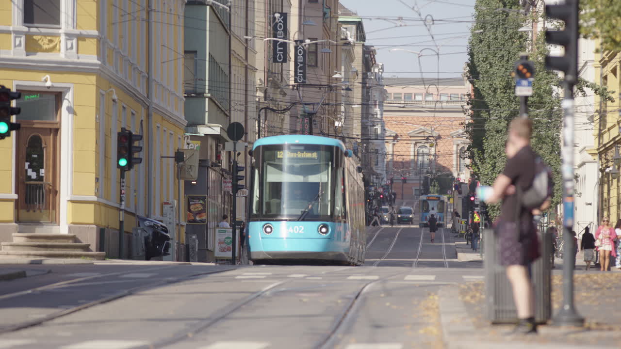 Trams on tram lines with people walking around Prinsens gate, Kvadraturen, Oslo