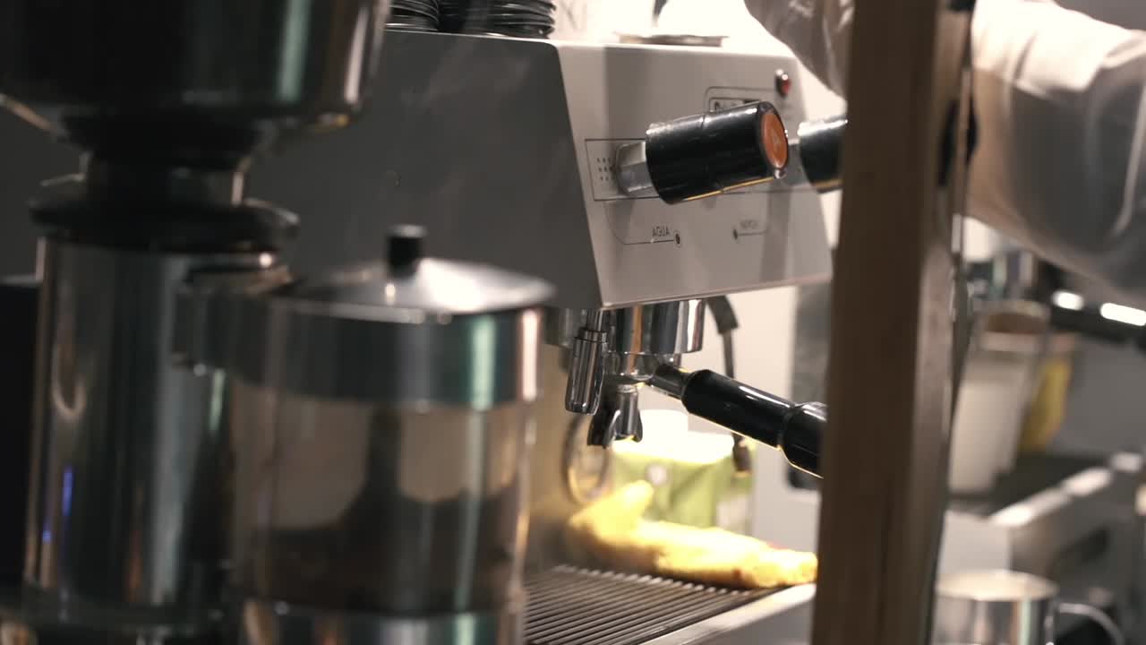 Detail close-up barista yang sedang membuat espresso dari mesin kopi profesional dengan fokus pada group head dan handle selama persiapan kopi di lingkungan kafe