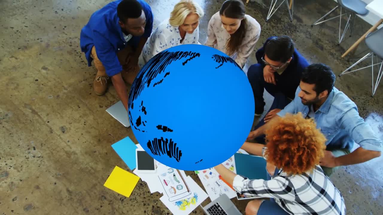 animación de un globo azul girando sobre diversos colegas creativos haciendo lluvia de ideas en el piso de la oficina