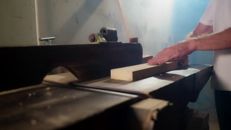 man planing wood with a wood planer