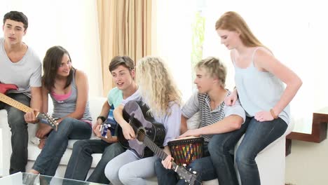 Adolescentes-Tocando-La-Guitarra-En-Casa.