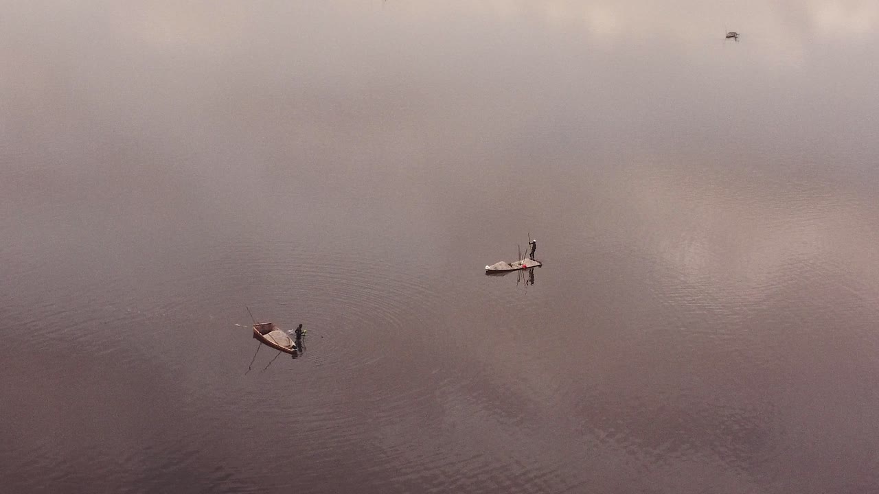 다카르 호수에서 소금 추출 작업자 2명 주위를 회전하는 항공 샷, 표면에 구름이 반사됨
