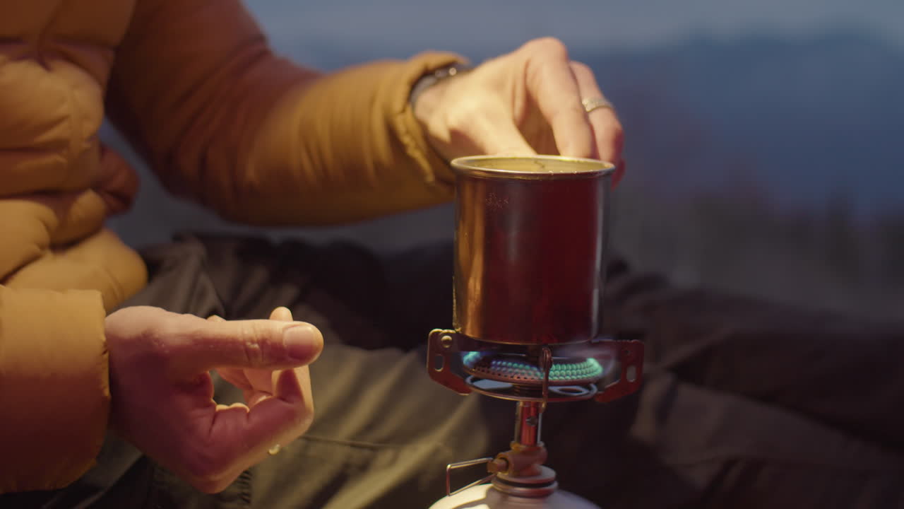 Man Using Portable Gas Stove in Camping Tent
