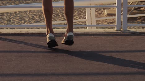 woman's legs jumping on a beach