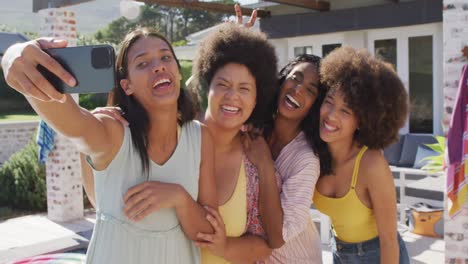 happy diverse female friends taking selfies and smiling at swimming pool party