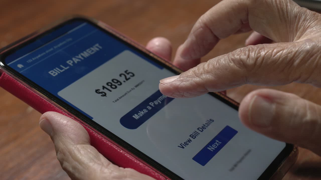 mujer anciana confundida y tratando de pagar la factura en el teléfono celular