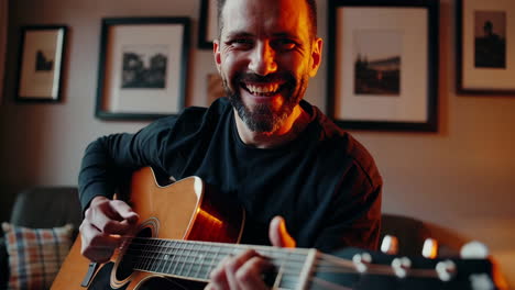 man playing acoustic guitar at home