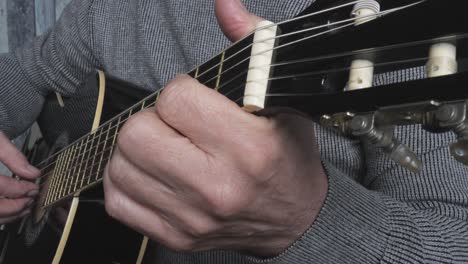 acústica, guitarra negra en las manos del hombre