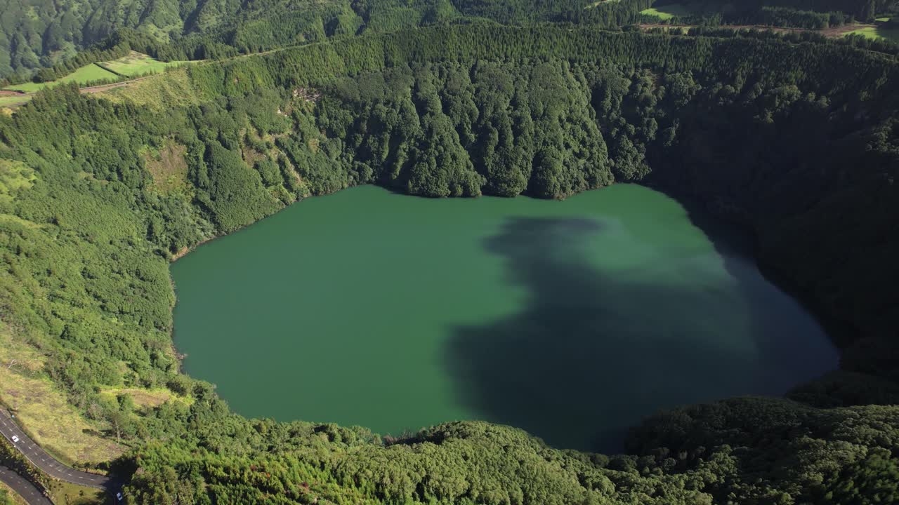 Lagoa de Santiago in Sete Cidades revealed in a slow aerial circle within a volcanic crater on Sao Miguel in the Azores