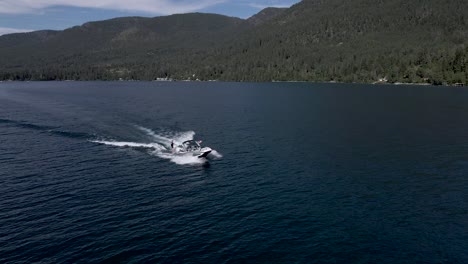 Zeitlupendrohne-Umkreist-Den-Wakeboarder,-Der-Von-Einem-Schnellboot-Gezogen-Wird