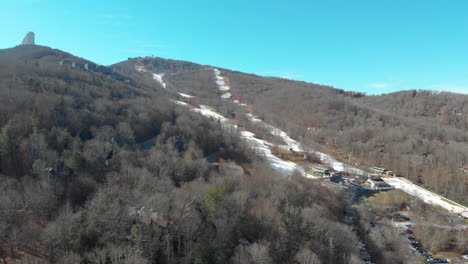 a drone shot of a mountain in winter and the ski slopes