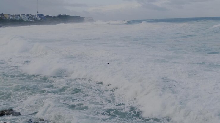 Men Swimming At The Bronte Beach With Huge Waves Rolling To The Shore - Sydney, NSW, Australia - wide shot