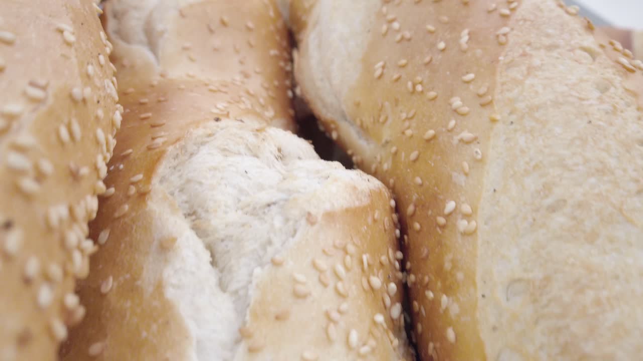 Ingrandisci, esegui una panoramica ravvicinata su pagnotte di pane fresco mostrando la crosta e la consistenza della farina