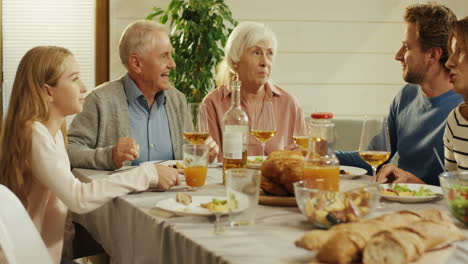 Family-Dinner-Of-The-Two-Kids,-Their-Parents-And-Grandparents-On-A-Holiday-In-The-Cozy-Living-Room-At-Home