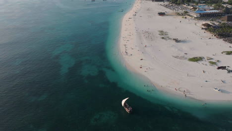 Vista-Aérea-De-Un-Barco-De-Madera-Navegando-Cerca-De-La-Maravillosa-Playa-De-Zanzíbar,-Filmada-A-30-Fps