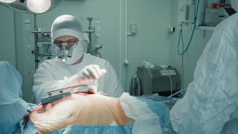 surgeon turns retractor lever to expand incision. cardiologist opens access to ill heart with tools for coronary artery bypass surgery in clinic