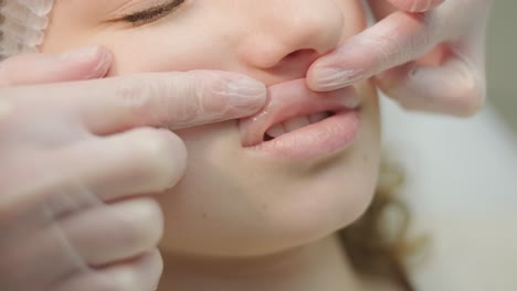 close-up of cosmetologist's hands examining lips