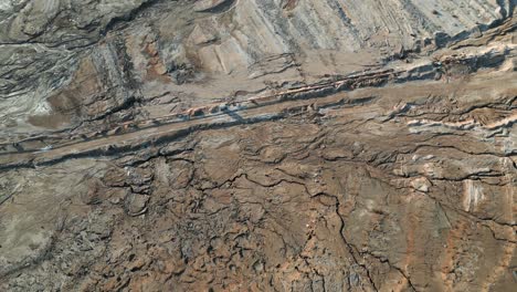 Nach-Unten-Geneigte-Luftaufnahme-Eines-Salzsees-Mit-Felsiger-Küstendrohne,-Die-An-Einem-Sonnigen-Tag-über-Die-Berühmte-Malerische-Küste-Des-Toten-Meeres-Fliegt