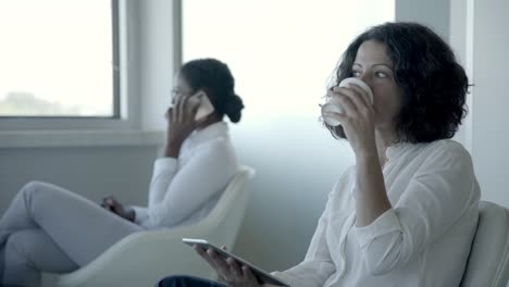 mujeres de negocios con tabletas digitales y teléfonos inteligentes
