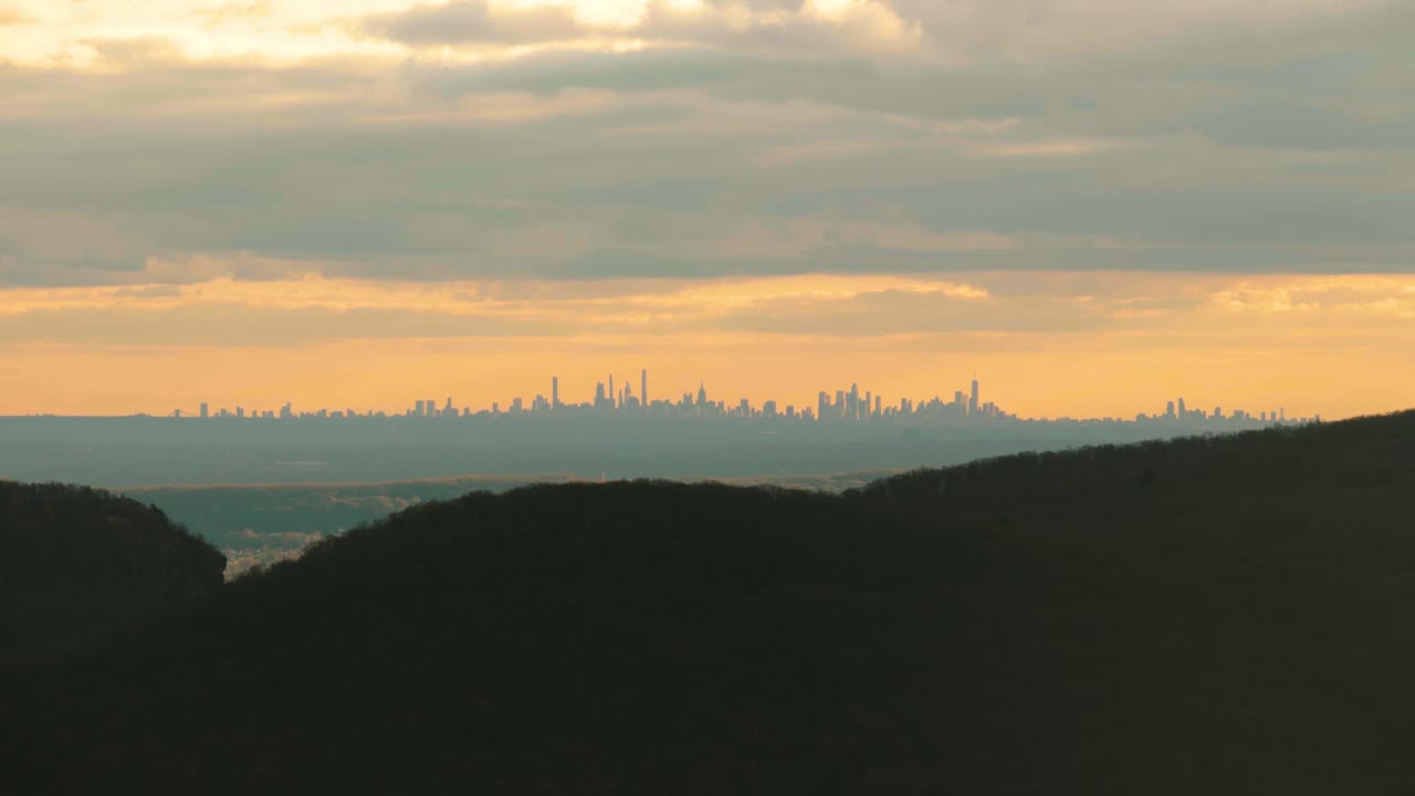 la puesta de sol naranja nublada del horizonte de nyc desde lejos a kilómetros de distancia