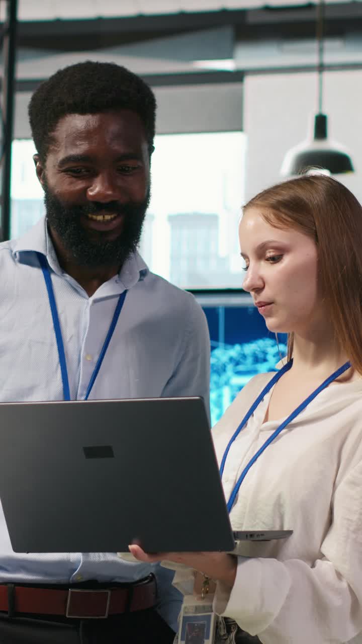 Vertical video Junior dev and colleague in office reviewing AI system metrics