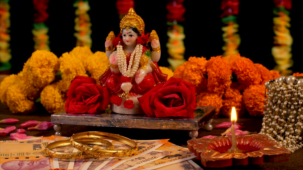 Diwali celebration - Indian women lighting diya for performing goddess Lakshmi puja
