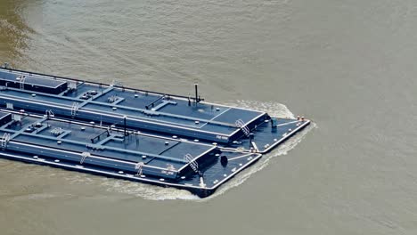 flat-bottomed barge pushed by towboat in mississippi river in new orleans, usa. - wide shot