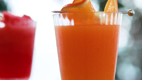jugos de naranja y sandía en un entorno tropical