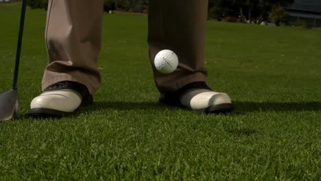 golf ball falling beside golfers feet and club