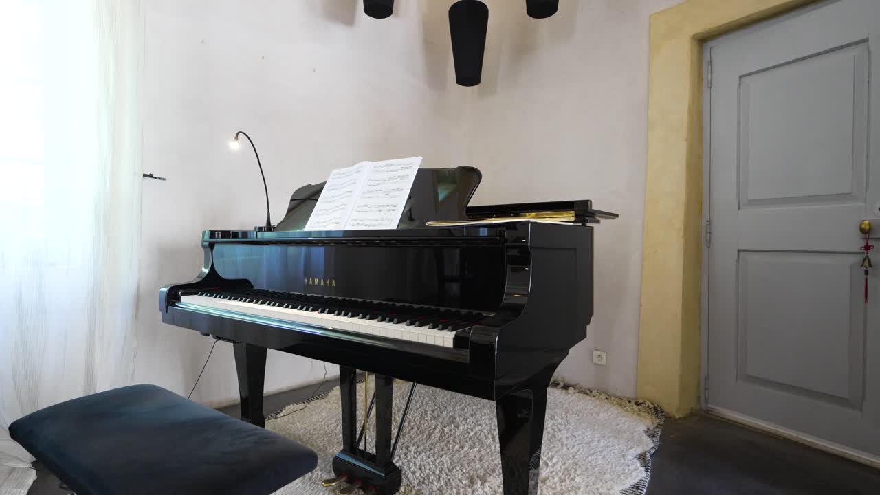 Ripresa orbitante lenta di un bellissimo pianoforte posizionato nell'angolo di una sala da musica.