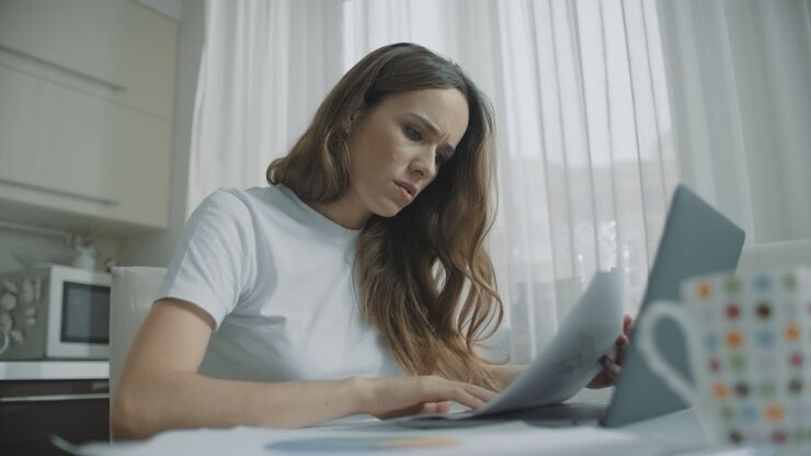 Skupiona kobieta biznesu pracująca z dokumentami w domu.