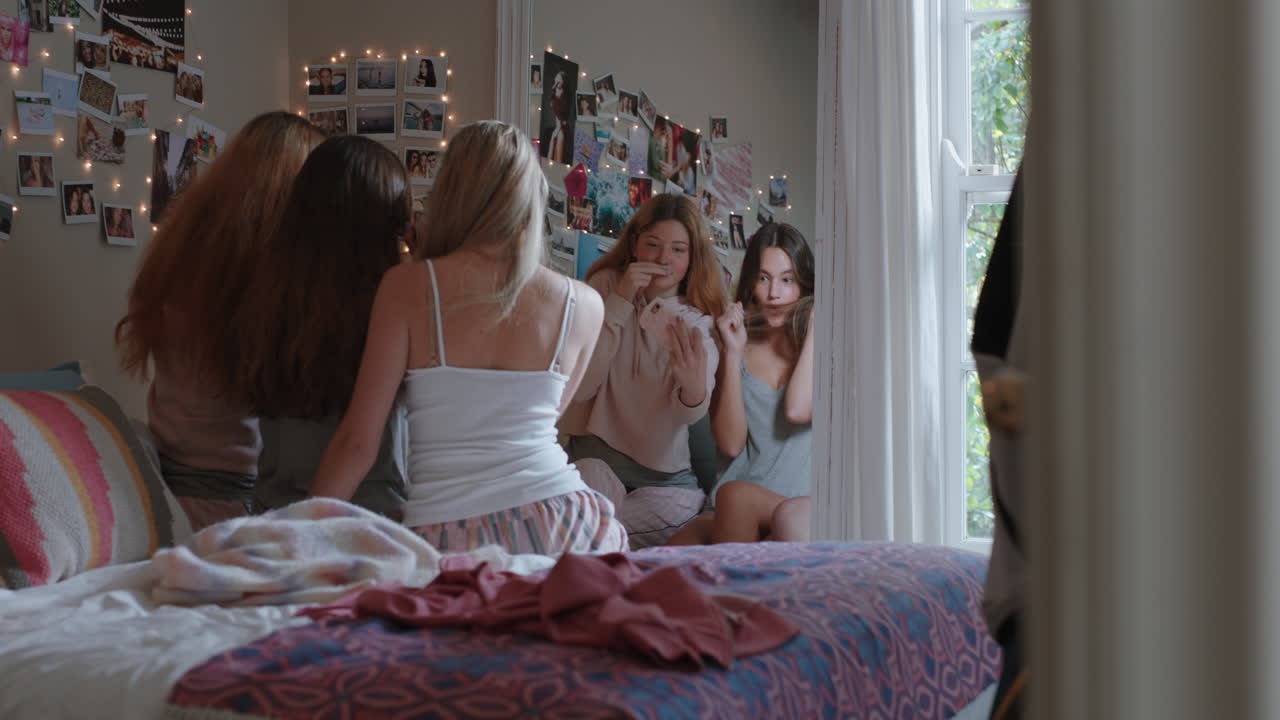 행복한 십대 소녀들이 스마트폰을 사용하여 함께 셀카 사진을 찍고 가장 친한 친구들이 포즈를 취하고 얼굴을 짓는 것을 즐기고 집에서 주말을 소셜 미디어에서 공유합니다.