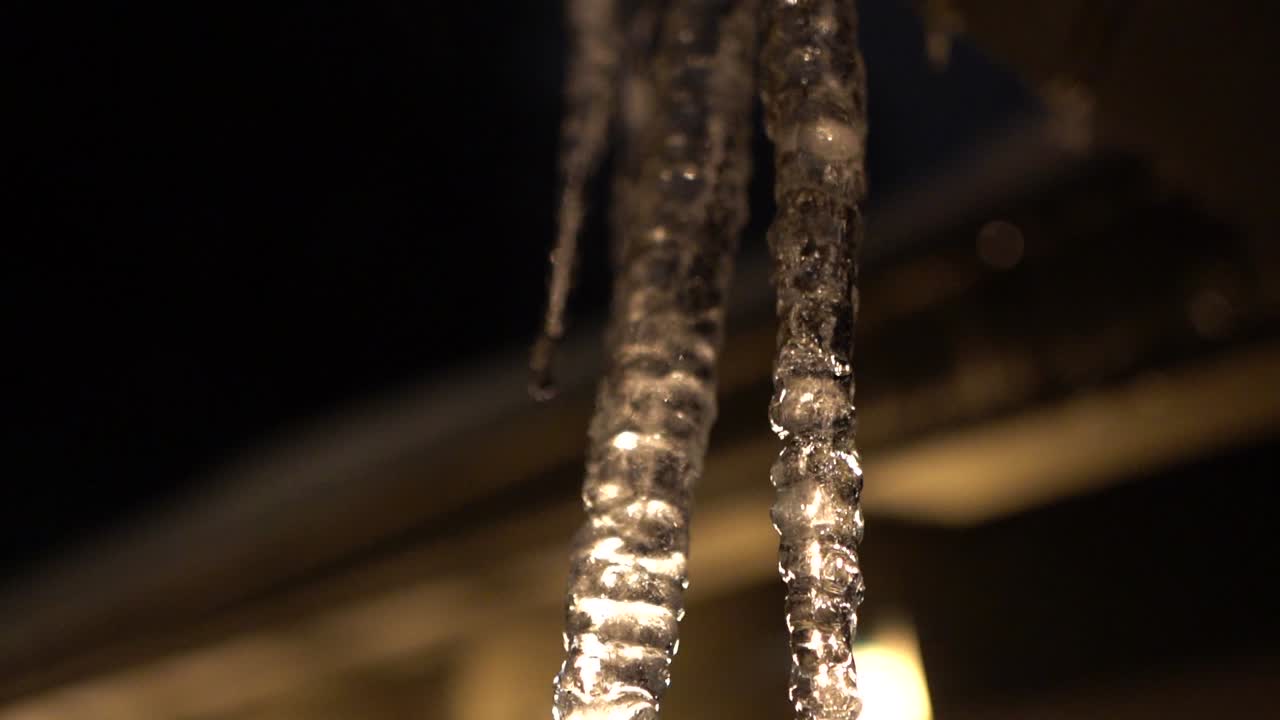 지붕에 매달려 있는 백라이트 녹는 고드름, 슬로우 모션으로 떨어지는