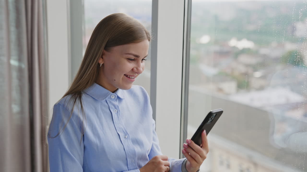 Woman using smartphone by window