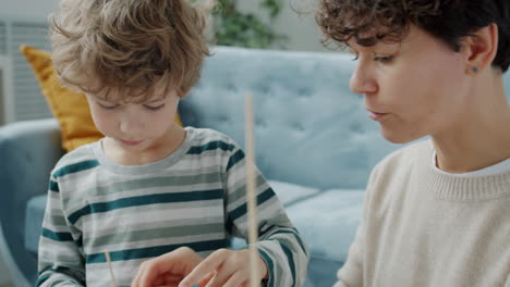 mother and child building with playdough and sticks