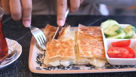 turkish breakfast: a delicious plate of cheese pastry, tomatoes, cucumber and tea