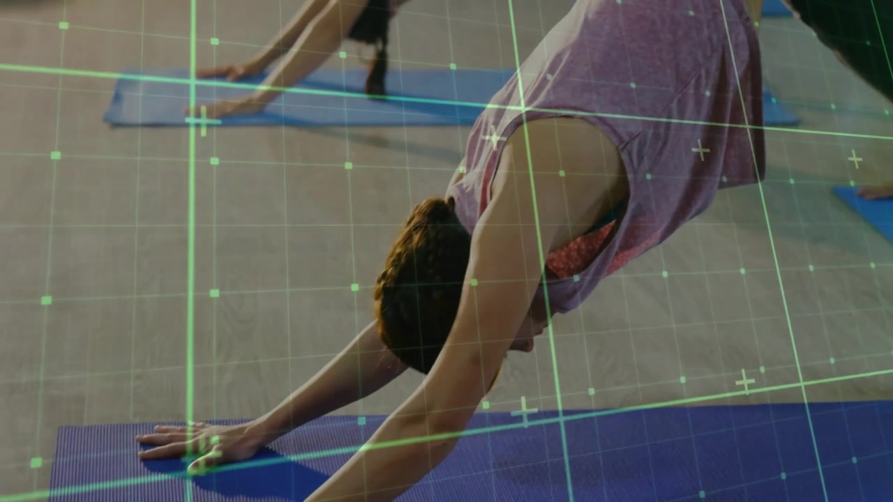 Gruppo che pratica yoga su tappetini blu in uno studio fitness, tracciando il movimento con una sovrapposizione di griglia verde