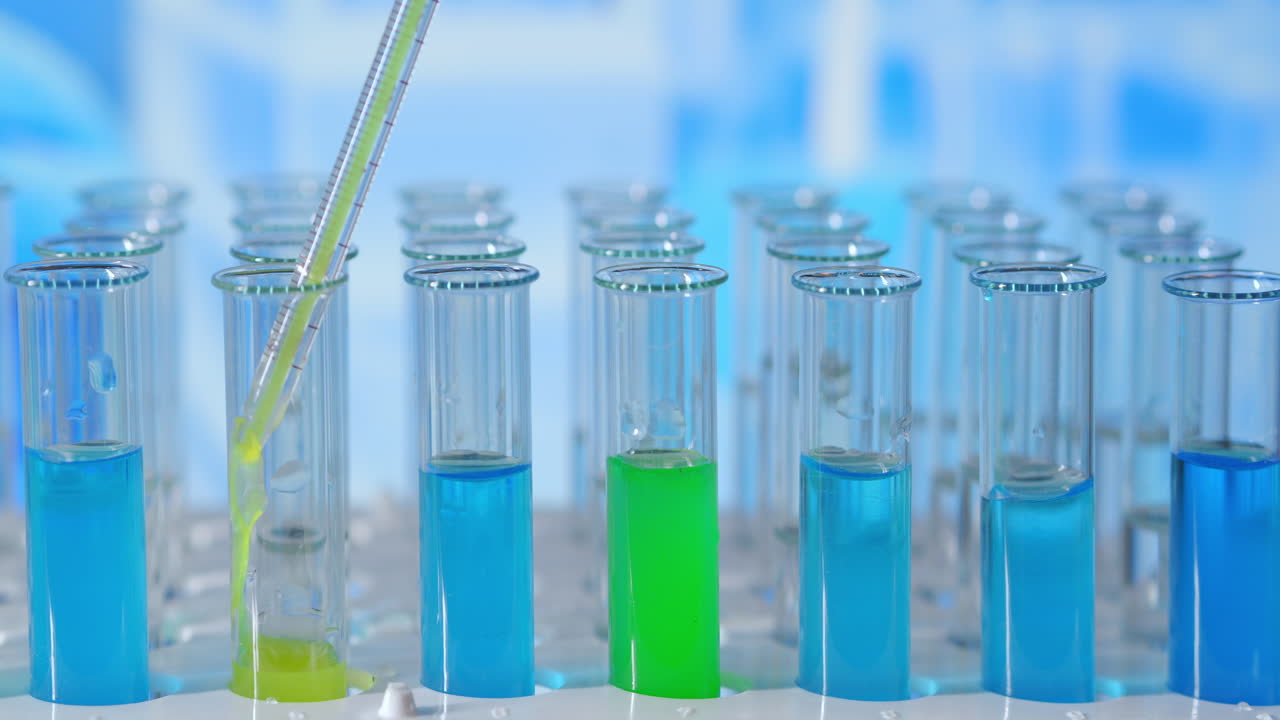 en un laboratorio un científico con una pipeta analiza un líquido coloreado para extraer el adn y las moléculas en los tubos de ensayo. concepto: investigación bioquímica naturaleza medicina farmacéutica. imágenes de alta calidad 4k