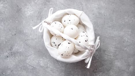 composition of white traditional dotted easter eggs in white wicker basket