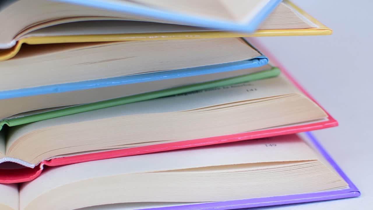 Desk with stack of open study books. Textbooks for the student, university. Study from home. Distance education concept.