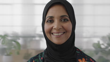 portrait of elegant muslim business woman smiling looking happy at camera wearing traditional headscarf mature experienced female in office workspace