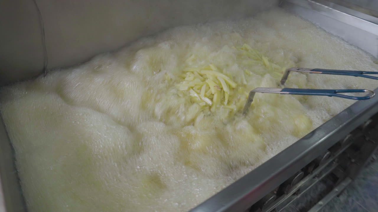 Ready Meal Production line in a factory, The Chef frying the French fries in a big fryer