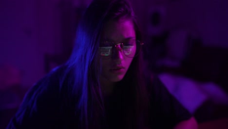mujer joven enfocada codificando tarde en la noche